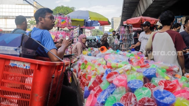 Warga membeli terompet di Pasar Asemka, Jakarta, Jumat (29/12/2023). [Suara.com/Alfian Winanto]