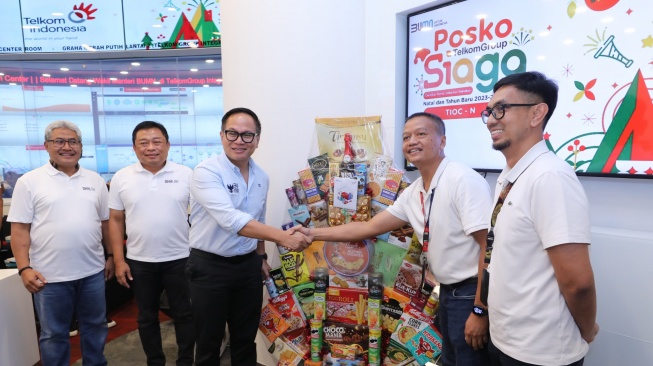 Deputy Minister of State-Owned Enterprises (BUMN) Kartika Wirjoatmodjo (third from left) witnessed by Telkom Main Director Ririek Adriansyah (second from left) and Telkom Network & IT Solution Director Herlan Wijanarko (far left), handing over symbolic gifts to the post personnel on duty at Telkom Integrated Operation Center Telkom in a series of visits to the TelkomGroup SIAGA NARU 2023/2024 Command Post in Newsdelivers.com, Friday (29/12).