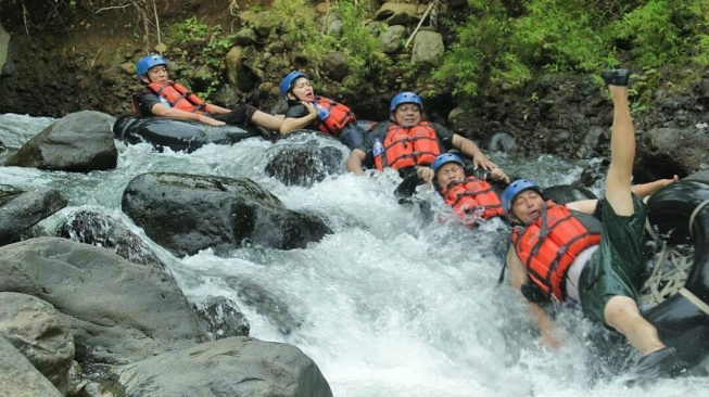 Seumlah wisatawan menikmati sensasi arum jeram Tubing Cikalimpang di Serang, Banten. [Instagram @wowbanten]