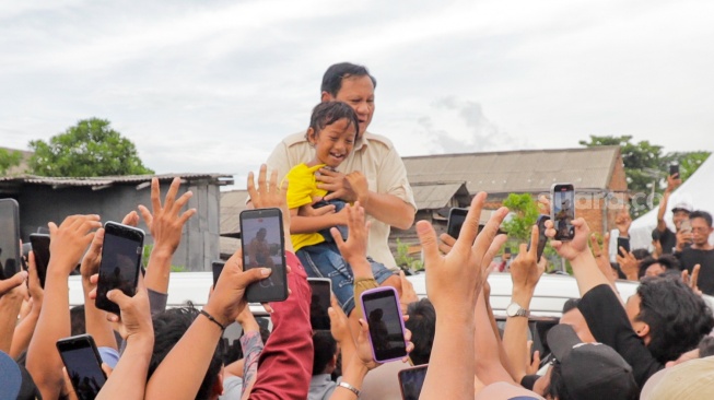 Calon presiden nomor urut 2 Prabowo Subianto berjabat tangan dengan warga usai acara Masakan Besar di Cilincing, Jakarta, Sabtu, (30/12/2023). [Pahami.id/Alfian Winanto]