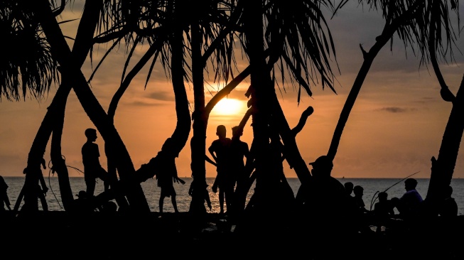 Sejumlah pengunjung menikmati suasana matahari terbenam (sunset) akhir tahun 2023 di kawasan pantai, Senggigi, Lombok Barat, NTB, Minggu (31/12/2023). [ANTARA FOTO/Ahmad Subaidi/rwa]