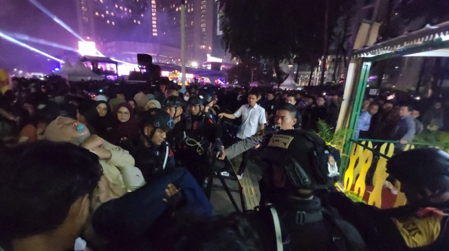 Sejumlah warga jatuh pingsan di kawasan Bundaran Hotel Indonesia (HI) pada malam pergantian tahun 2024, Minggu (31/12/2023). [Suara.com/Fakhri]