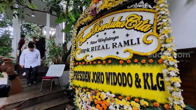 Karangan bunga ucapan duka cita dari Presiden Joko Widodo atau Jokowi melawan meninggalnya ekonom senior Rizal Ramli pada depan rumah duka di area Jalan Bangka IX, Ibukota Indonesia Selatan, Rabu (3/1/2023). (Suara.com/Novian)