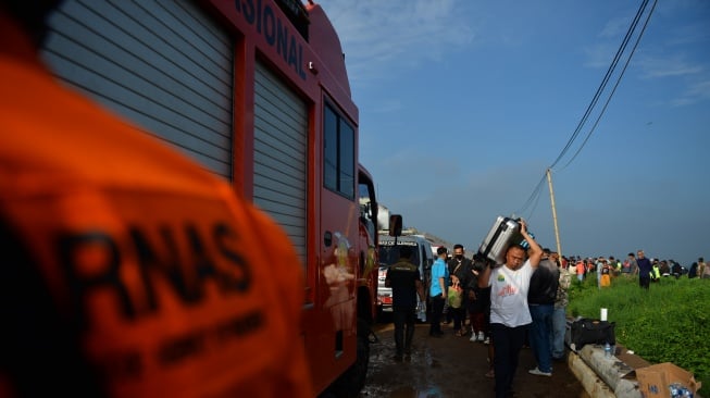 Sejumlah penumpang mengevakuasi barangnya saat terjadinya tabrakan kereta api lokal Bandung Raya yang bertabrakan dengan kereta api Turangga di Cicalengka, Kabupaten Bandung, Jawa Barat, Jumat (5/1/2024). [ANTARA FOTO/Raisan Al Farisi]