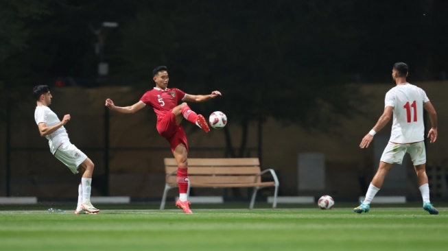 Bek Timnas Indonesia, Rizky Ridho menahan bola saat menghadapi Iran dalam laga uji coba jelang Piala Asia 2023 di Al Rayyan Training Site, Selasa (9/1/2024). [Dok. PSSI]