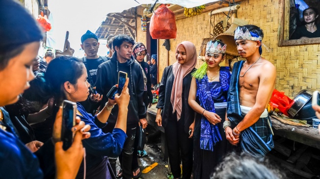 Warga berfoto bersama pengantin Badui di Kampung Kaduketug, Lebak, Banten, Kamis (11/1/2024).  [ANTARA FOTO/Muhammad Bagus Khoirunas/nz]