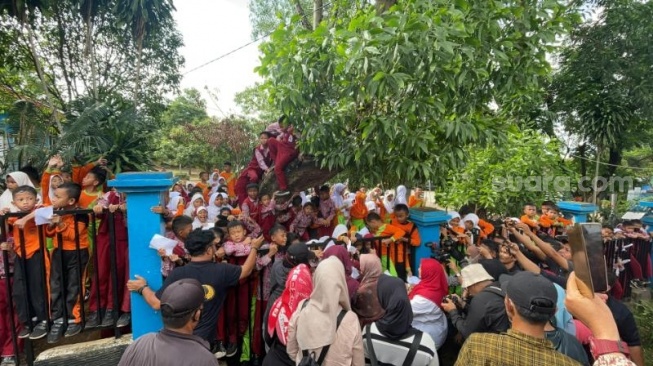 Istri calon presiden nomor urut 3, Ganjar Pranowo, Siti Atikoh Supriyanti meladeni permintaan anak-anak SD sebelum melakukan silaturahmi ke Pondok Pesantren Sultan Mahmud Badaruddin II, Palembang, Sumatera Selatan, Kamis (11/1/2024). (Suara.com/Bagaskara)