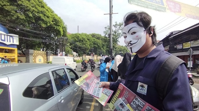 Sejumlah Mahasiswa Bertopeng Turun ke Jalan Bagikan Selebaran Penolakan Dinasti Politik Depan Kampus UIN Jakarta