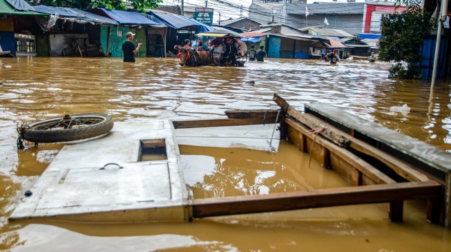 Warga menaiki delman melewati genangan banjir di Dayeuhkolot, Kabupaten Bandung, Jawa Barat, Jumat (12/1/2024). [ANTARA FOTO/Novrian Arbi/tom]