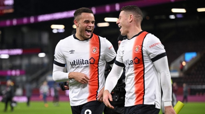 Striker Luton Town Carlton Morris (Kiri) dan Ross Barkley (kanan) tersenyum usai pertandingan Liga Inggris kontra Burnley di Turf Moor, Sabtu (13/1/2024).Oli SCARFF / AFP