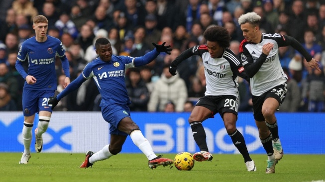 Gelandang Chelsea #25 Moises Caicedo bersaing dengan gelandang Fulham #20 Willian selama pertandingan pekan ke-21 Liga Inggris 2023-2024 antara Chelsea vs Fulham di Stamford Bridge, London pada 13 Januari 2024.Adrian DENNIS / AFP.