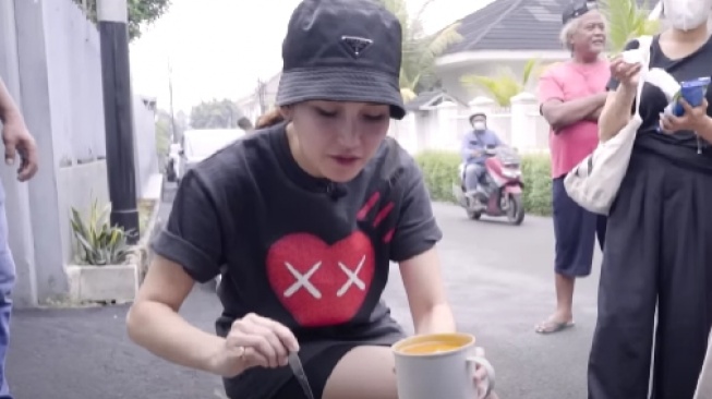 Gaya Ayu Ting Ting makan bakso di pinggir jalan. (YouTube/Qiss You TV)