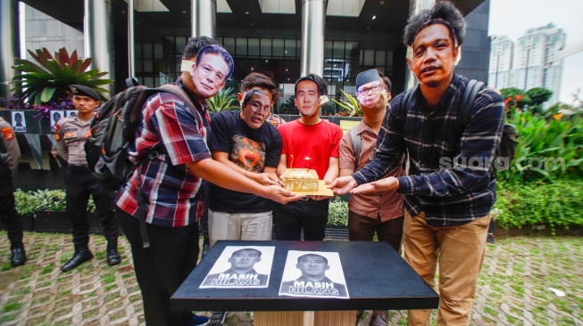 Aktivis dari Indonesia Corruption Watch (ICW)  menggelar aksi teaterikal menggunakan topeng Harun Masiku di depan gedung Merah Putih KPK, Jakarta, Senin (15/1/2024). [Suara.com/Alfian Winanto]