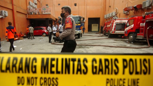 Polisi berjaga di tempat kejadian perkara (TKP) kebakaran tempat hiburan malam di Tegal, Jawa Tengah, Senin (15/1/2024). [ANTARA FOTO/Oky Lukmansyah].