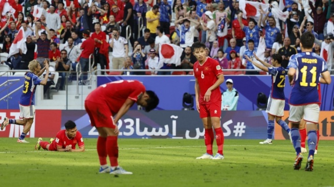 Ekspresi para pemain Timnas Vietnam (jersey merah) pada laga Piala Asia 2023 kontra Jepang di Stadion Al Thumama, Doha, Qatar, Minggu (14/1/2024). [KARIM JAAFAR / AFP]