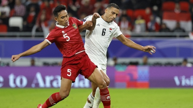 Bek Timnas Indonesia, Rizky Ridho (kiri) tampil pada laga Piala Asia 2023 kontra Irak di area Stadion Ahmed bin Ali, Al Rayyan, Qatar, Hari Senin (15/1/2024) di malam hari WIB. [KARIM JAAFAR / AFP]