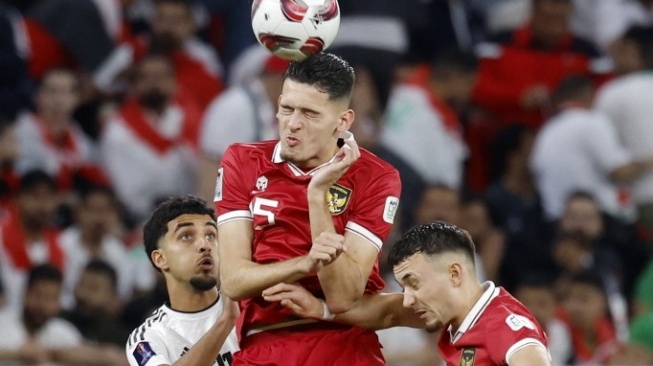 Bek timnas Indonesia Justin Hubner bertarung memperebutkan bola dengan gelandang Irak Zidane Iqbal pada pertandingan Grup D Piala Asia 2023 antara timnas Indonesia vs Irak di Stadion Ahmad bin Ali di Al-Rayyan, sebelah barat Doha pada 15 Januari 2024.KARIM JAAFAR / AFP.