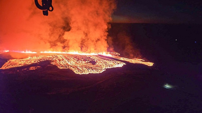 Penampakan lava yang mengalir saat letusan gunung berapi di pinggiran kota Grindavik, Islandia barat, Minggu (14/1/2024). [Icelandic Department of Civil Protection and Emergency Management / AFP]
