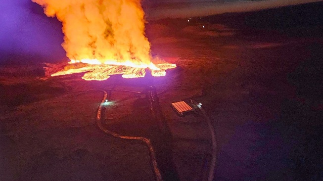 Penampakan lava yang mengalir saat letusan gunung berapi di pinggiran kota Grindavik, Islandia barat, Minggu (14/1/2024). [Icelandic Department of Civil Protection and Emergency Management / AFP]
