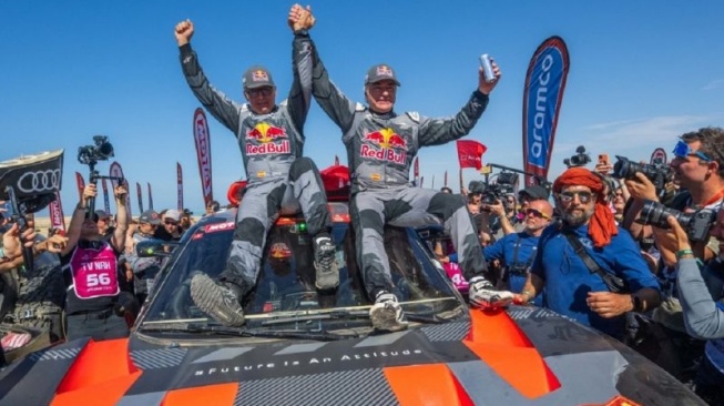 Driver tim Audi Sport Carlos Sainz dan co-driver Lucas Cruz melakukan selebrasi setelah menjuarai Reli Dakar 2024 di Yanbu, Arab Saudi, Jumat (19/1/2024) [AFP/Patrick Hertzog via ANTARA]