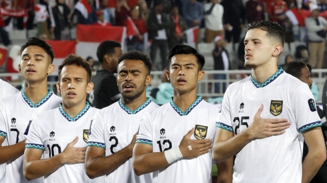 Pemain Indonesia menyanyikan lagu kebangsaan jelang dimulainya laga kedua Grup D Piala Asia 2023 antara Vietnam vs Timnas Indonesia di Stadion Abdullah bin Khalifa Doha pada 19 Januari 2024. KARIM JAAFAR / AFP.