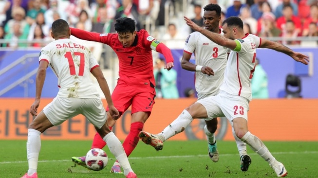 Bek Yordania #23 Ehsan Haddad berebut bola melawan striker Korea Selatan #07 Son Heung-min pada pertandingan kedua Grup E Piala Asia 2023 antara Yordania vs Korea Selatan di Stadion Al-Thumama di Doha pada 20 Januari 2024.Giuseppe CACACE / AFP.