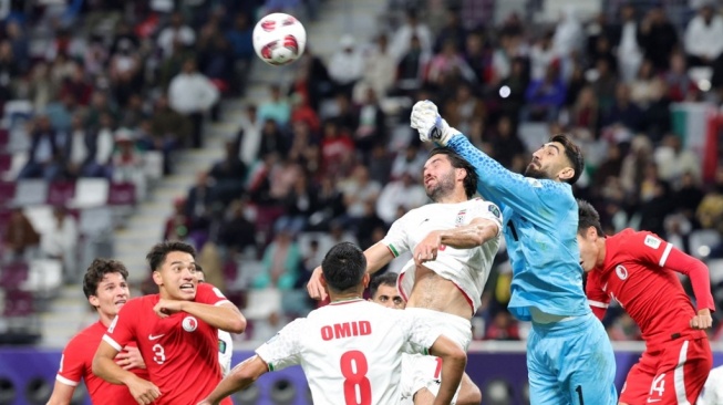 Kiper Iran Alireza Beiranvand meninju bola dalam laga Grup C Piala Asia 2023 kontra Hong Kong di Stadion Internasional Khalifa di Doha pada 19 Januari 2024.Giuseppe CACACE / AFP