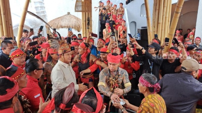 Sambutan meriah dari Pasukan Merah terhadap calon presiden (capres) nomor urut 2 Prabowo Subianto di Rumah Adat Radakng, Kota Pontianak, Sabtu (20/1/2024). (Suara.com/Novian)