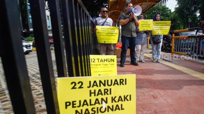 Aktivis dari Koalisi Pejalan Kaki menggelar aksi di Halte Tugu Tani, Jakarta, Senin (22/1/2024). [Suara.com/Alfian Winanto]