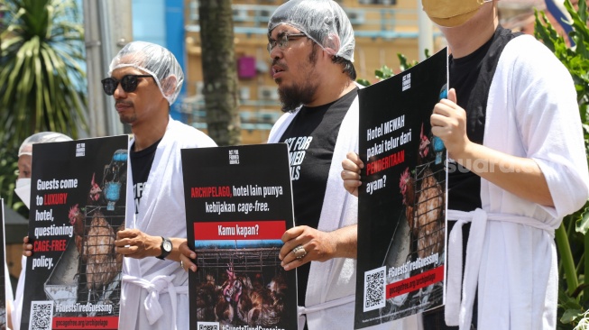 Sejumlah aktivis Act For Farmed Animals (AFFA) memakai jubah mandi sambil melakukan aksi di depan Hotel Aston Bellevue Radio Dalam, Senin (22/1/2024). [Suara.com/Alfian Winanto]