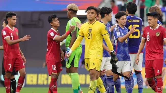 Pemain Indonesia dan Jepang saling memberi hormat usai pertandingan sepak bola Grup D Piala Asia 2023 di Stadion al-Thumama Doha pada 24 Januari 2024.Giuseppe CACACE / AFP