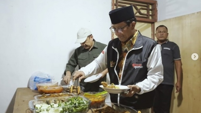 Calon Wakil Presiden Mahfud MD menikmati makanan rumah pada rumah warga, ketika kunjungan ke Lampung [Suara.com/Instagram Mahfud MD]