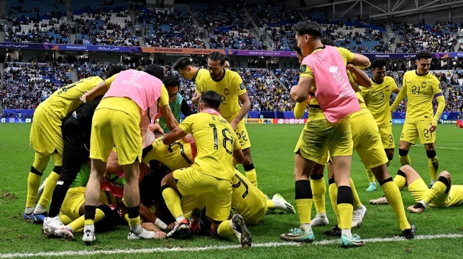 Para pemain Tanah Melayu merayakan gol ketiga timnya pada pertandingan Grup E Piala Asia 2023 kontra Korea Selatan dalam Stadion Al-Janoub di dalam al-Wakrah, selatan Doha, pada 25 Januari 2024.HECTOR RETAMAL / AFP