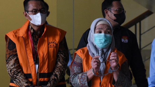 Dirjen Pembinaan Penempatan Tenaga Kerja Kementerian Tenaga Kerja dan Transmigrasi, Reyna Usman (kanan) dan Pejabat Pembuat Komitmen Pengadaan Sistem Proteksi TKI Kemnakertrans I Nyoman Darmanta (kiri) berjalan menuju ruang konferensi pers penetapan dan penahanan tersangka usai menjalani pemeriksaan di Gedung Merah Putih KPK, Jakarta, Kamis (25/1/2024). [ANTARA FOTO/Indrianto Eko Suwarso].