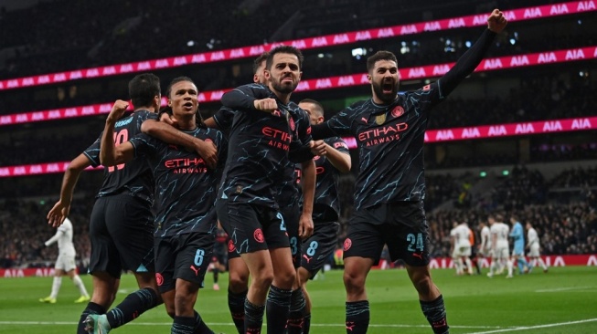 Bek Manchester City asal Belanda, Nathan Ake (dua dari kanan) melakukan selebrasi bersama bersama rekan satu timnya setelah mencetak gol pembuka pertandingan putaran keempat Piala FA 2023-2024 antara Tottenham Hotspur vs Manchester City di Stadion Tottenham Hotspur di London, pada 26 Januari 2024. City memenangkan pertandingan tersebut dengan skor 1-0.Glyn KIRK / AFP.