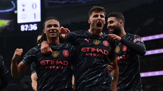 Bek Manchester City asal Belanda, Nathan Ake (kiri) melakukan selebrasi bersama Ruben Dias (tengah) dan Josko Gvardiol (kanan) setelah mencetak gol pembuka pertandingan putaran keempat Piala FA 2023-2024 antara Tottenham Hotspur vs Manchester City di Stadion Tottenham Hotspur di London, pada 26 Januari 2024. City memenangkan pertandingan tersebut dengan skor 1-0.Glyn KIRK / AFP.