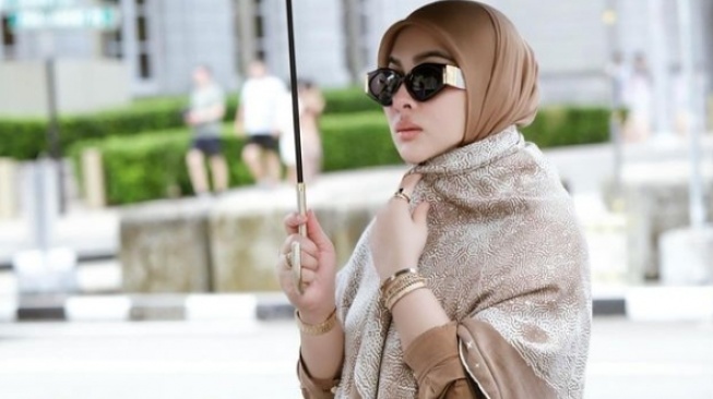 Syahrini covers her stomach after being hit by pregnancy issues (Instagram)