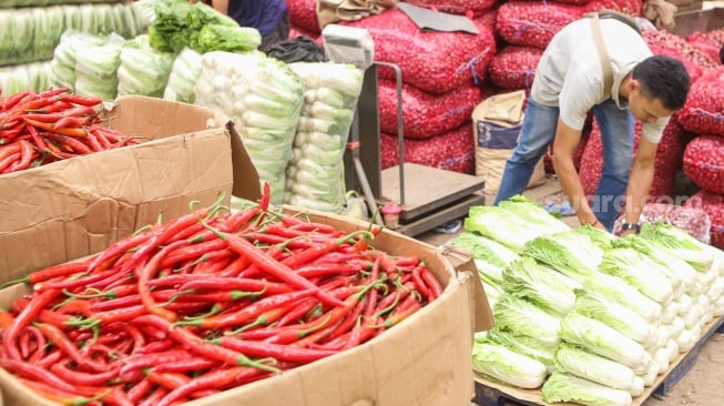 Pedagang menata barang dagangannya di Pasar Induk Kramat Jati, Jakarta, Senin (29/1/2024). [Suara.com/Alfian Winanto]