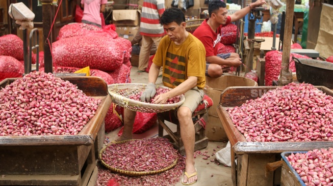 Pedagang menata barang dagangannya di Pasar Induk Kramat Jati, Jakarta, Senin (29/1/2024). [Suara.com/Alfian Winanto]