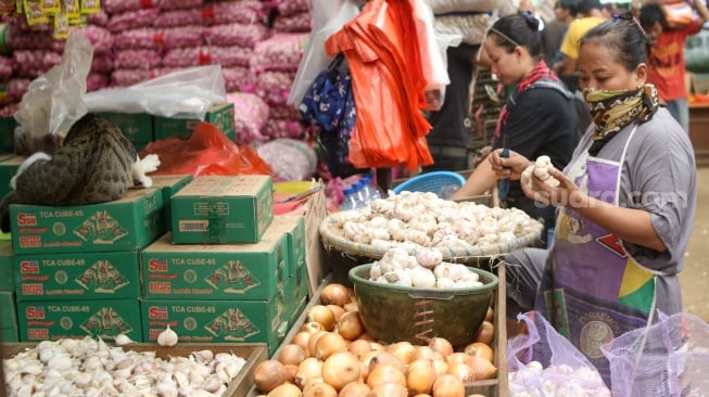 Pedagang menata barang dagangannya di Pasar Induk Kramat Jati, Jakarta, Senin (29/1/2024). [Suara.com/Alfian Winanto]