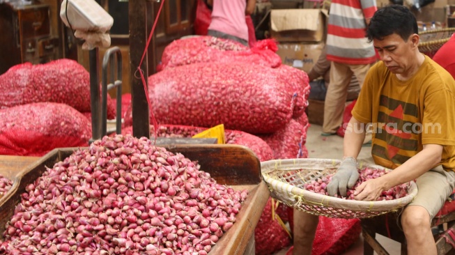 Pedagang menata barang dagangannya di Pasar Induk Kramat Jati, Jakarta, Senin (29/1/2024). [Suara.com/Alfian Winanto]