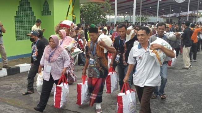 Warga meninggalkan Gudang Bulog Pajangan Bantul usai menerima bantuan pangan beras yang dihadiri Presiden Joko Widodo. Selasa (30/1/2024) (ANTARA/Hery Sidik)