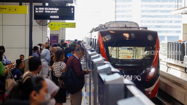 Penumpang menunggu kedatangan kereta LRT Jabodebek di Stasiun Dukuh Atas, Jakarta, Selasa (30/1/2024). [Suara.com/Alfian Winanto]