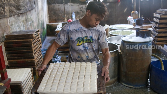 Pekerja menyelesaikan pembuatan tahu di pabrik kawasan Duren Tiga, Jakarta, Rabu (31/1/2024). [Suara.com/Alfian Winanto]