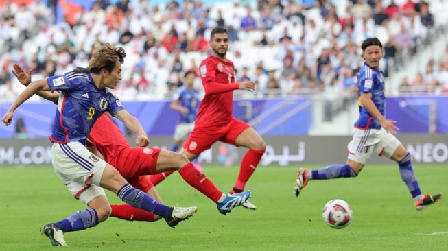 Penyerang Jepang Ayase Ueda mencetak gol ketiga timnya ke gawang Bahrain di babak 16 besar Piala Asia 2023 yang digelar di Stadion al-Thumama di Doha pada 31 Januari 2024.Giuseppe CACACE / AFP