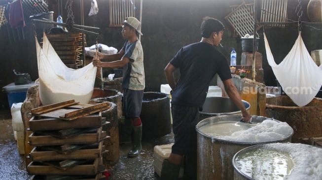 Pekerja menyelesaikan pembuatan tahu di pabrik kawasan Duren Tiga, Jakarta, Rabu (31/1/2024). [Suara.com/Alfian Winanto]