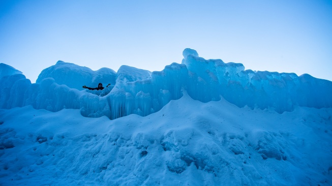 Orang-orang menjelajahi Ice Castles di North Woodstock, New Hampshire, Amerika Serikat, Kamis (1/2/2024). [Joseph Prezioso / AFP]