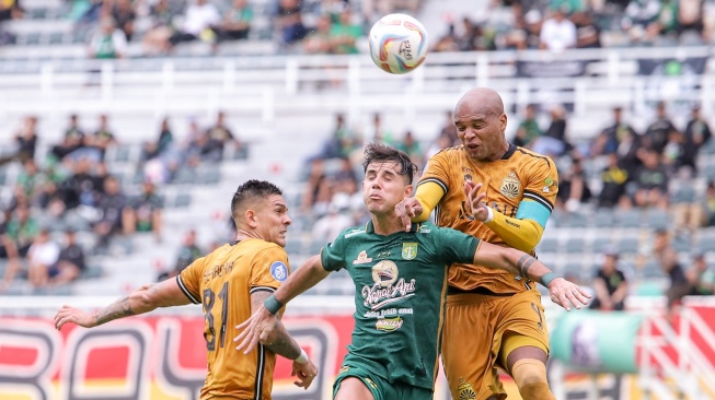 Pesepak bola Persebaya Surabaya Bruno Moreira Soares (tengah) berebut bola di udara dengan pesepak bola Bhayangkara Presisi Indonesia FC Anderson Aparecido Salles (kanan) dan Luis Marcelo Herrera (kiri) pada pertandingan BRI Liga 1 di Stadion Gelora Bung Tomo, Surabaya, Jawa Timur, Minggu (4/2/2024). Persebaya menang dengan skor 1-0. ANTARA FOTO/Rizal Hanafi/aww.