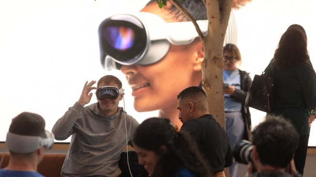 Seorang pelanggan mencoba Vision Pro-nya saat peluncurannya di Apple The Grove di Los Angeles, California, Amerika Serikat, Jumat (2/2/2024). [David SWANSON / AFP]