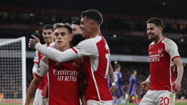 Gelandang Arsenal, Leandro Trossard (tengah) melakukan selebrasi bersama rekan-rekannya setelah mencetak gol ketiga timnya selama pertandingan pekan ke-23 Liga Inggris 2023-2024 antara Arsenal vs Liverpool di Stadion Emirates di London pada 4 Februari 2024.Ian Kington / IKIMAGES / AFP.